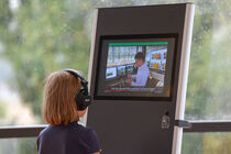 Kind mit Kopfhörer schaut sich ein Video des Sächsischen Landtags an.
