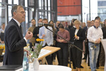 Landtagspräsident Dr. Matthias Rietschel spricht am Mikrofon vor vielen Gästen in der Lobby.