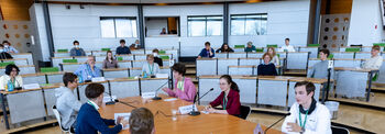 Im Plenarsaal sitzen an einem Diskussionstisch Schülerinnen und Schüler anlässlich des Jugendredeforums.