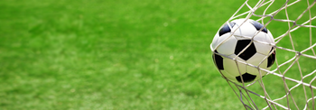 Ein Fußball wird in ein Fußballtor geschossen.
