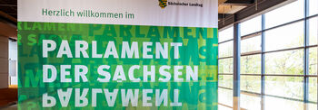 Auf einem grünen Banner steht in weißer Schrift 