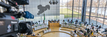 Blick in den Plenarsaal von oben, links im Bild ist eine Videokamera.