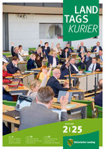 Abgeordnete sitzen im Plenarsaal und heben die Hände bei einer Abstimmung.