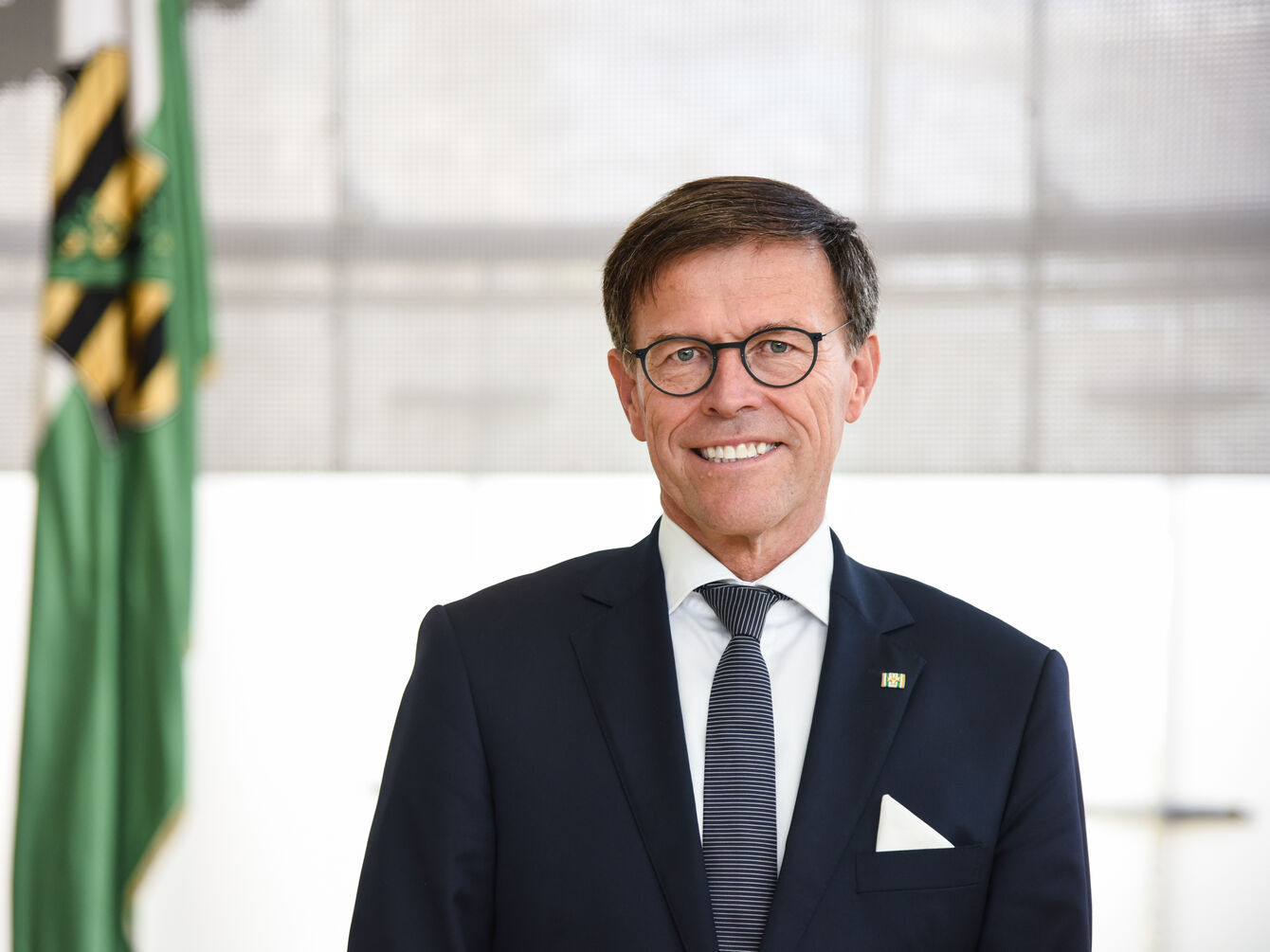 Landtagspräsident Dr. Matthias Rößler, Porträt vor Sachsenflagge