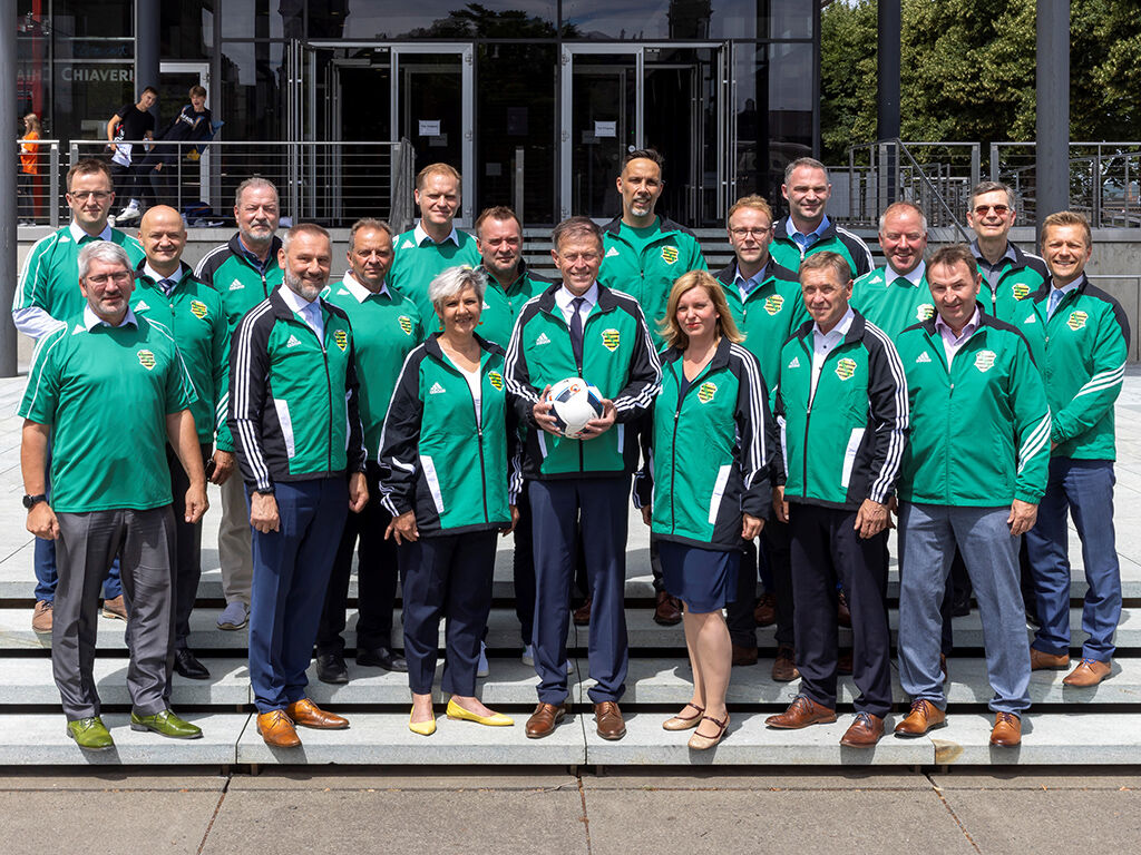 Mannschaftsfoto des FC Landtag vor dem Neubau mit Landtagspräsident Dr. Matthias Rößler (und Fußball)