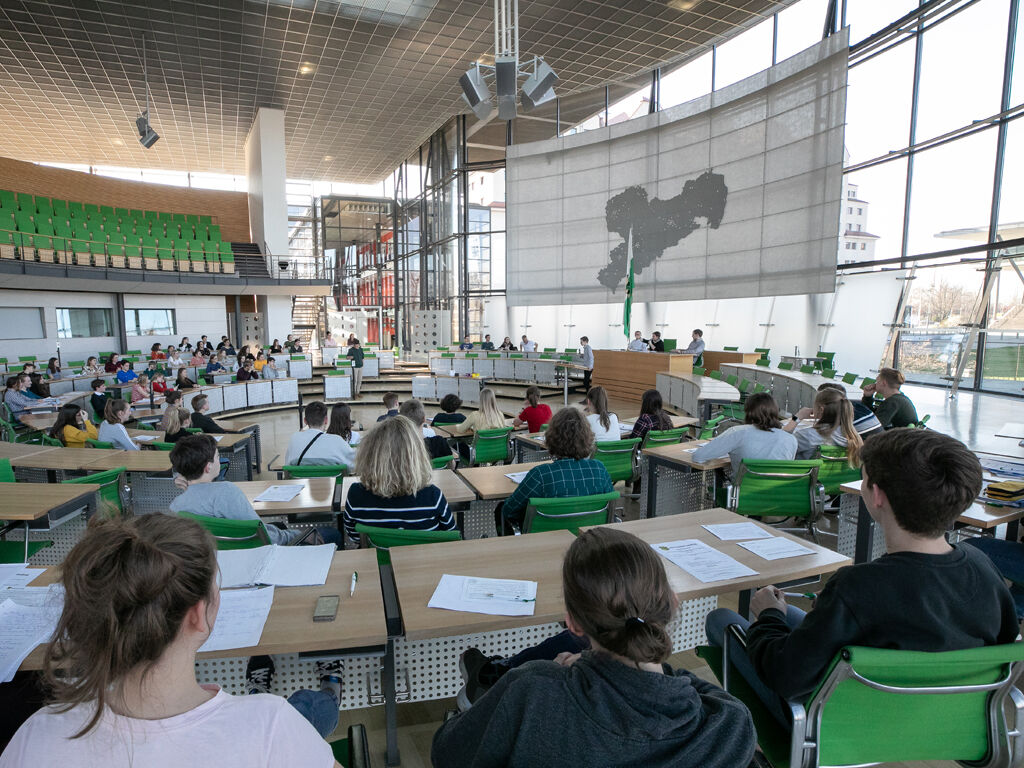 Im Plenarsaal sitzen Schülerinnen und Schüler auf den Plätzen der Abgeordneten.