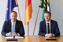 Landtagspräsident Alexander Dierks und Ministerpräsident Michael Kretschmer unterschreiben die Eilausfertigung des Haushaltsgesetztes.