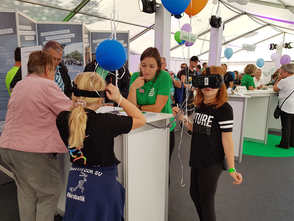 Beim Tag der Sachsen 2018 in Torgau stehen im Parlamentszelt stehen Besucher und Mitarbeiter des Landtags.