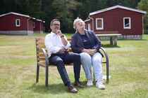 Sören Voigt und Sylvia Ott sitzen auf einer Bank und schauen in die Ferne.