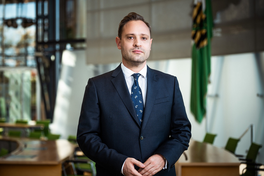 Landtagspräsident Alexander Dierks im Plenarsaal vor der Sachsenflagge