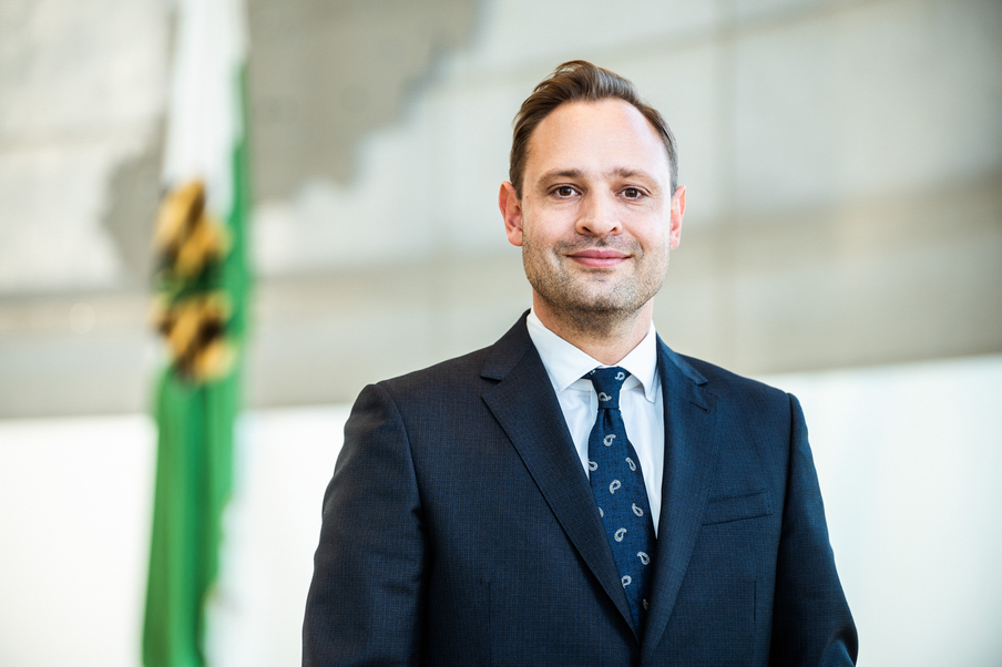 Landtagspräsident Alexander Dierks im Plenarsaal vor der Sachsenflagge