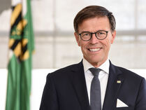 Landtagspräsident Dr. Matthias Rößler, Porträt mit Sachsenfahne im Hintergrund