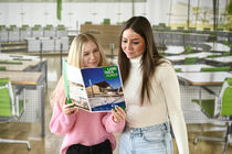 Auszubildende Sina Schemmrich und Katarina Berendt schauen in ein Heft des Landtagskuriers