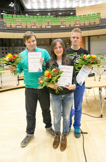 Die drei Sieger des Jugendredeforums halten glücklich ihre Urkunde sowie einen Blumenstrauß in die Kamera