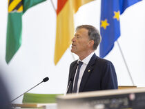Rede von Landtagspräsident Dr. Matthias Rößler, Fahnen im Hintergrund