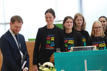 Der Ministerpräsident unterhält sich mit dne Mädchen des Gymnasiums aus Görlitz hinter dem Rednerpult im Plenarsaal