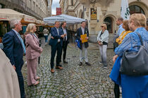 Die Delegierten stehen vor einer Gasse in Leipzig, in der Mitte ihr Stadtführer