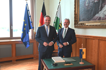 Alexander Dierks links, Mag. Karl Wilfing rechts, im Hintergrund die europäische, deutsche, sächsische Flagge