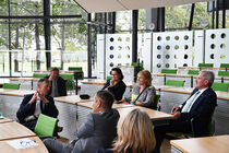 Die Delegierten sitzen im Gespräch mit Rösler auf den Stühlen des Plenarsaals