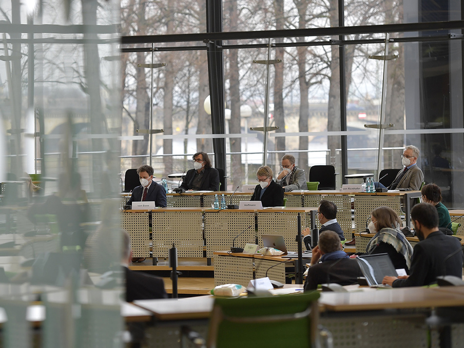 Abgeordnete und Sachkundige sitzen während der Anhörung im Plenarsaal.