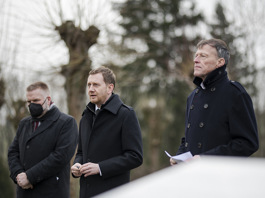 Dr. Markus Pieper, Ministerpräsident Michael Kretschmer und Landtagspräsident Dr. Matthias Rößler stehen nebeneinander an der Gedenkstätte.