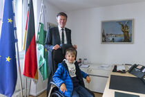 KInd auf dem Stuhl des Landtagspräsidenten in dessen Büro im Beisein von Dr. Matthias Rößler