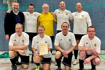 Mannschaftsfoto des FC Landtag in Radibor vor einem Tornetz mit Pokal und Urkunde