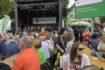 Besucher auf Bierzeltgarnituren vor der Bühne des Landtags