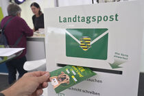 Postkarte wird in den Briefkasten geworfen