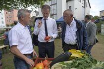 Landtagspräsident mit Gästen vor einem Obstkorb