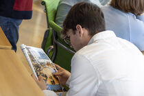 Junger Mann liest im Landtagskurier.