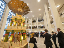 Zahlreiche Personen verfolgen den Pyramidenanschub im Atbaufoyer.