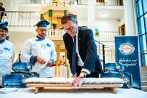 Landtagspräsident Dr. Matthias Rößler schneidet einen großen Stollen an.