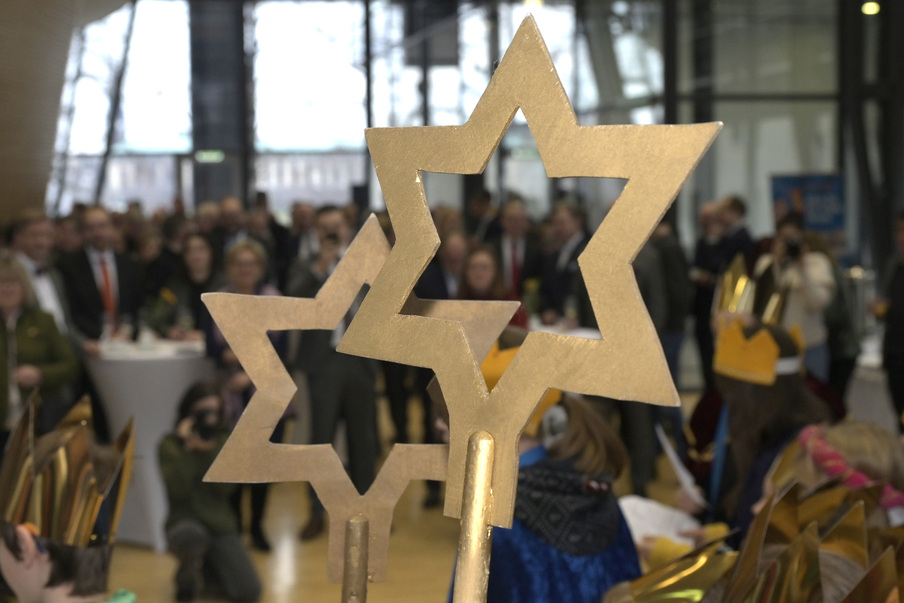 Blick durch eine goldene Sternenform auf die Gäste des Neujahrsempfangs in der Lobby.