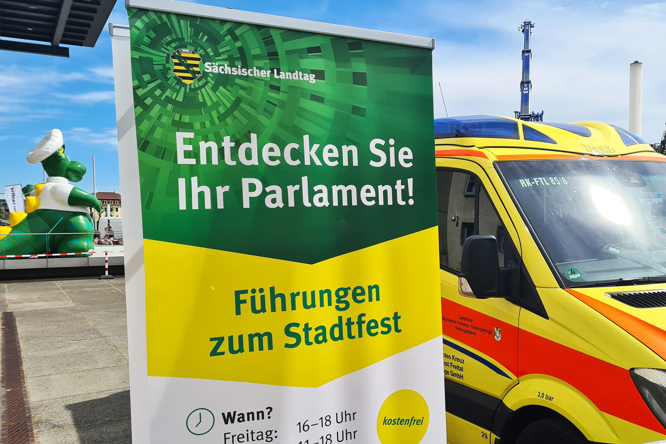 Werbeaufsteller für Führungen zum Stadtfest auf dem Vorplatz, im Hintegrund sind ein Rettungswagen sowie das Polizeimaskottchen Poldi zu erkennen.