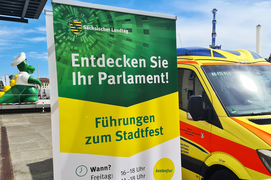 Werbeaufsteller für Führungen zum Stadtfest auf dem Vorplatz, im Hintegrund sind ein Rettungswagen sowie das Polizeimaskottchen Poldi zu erkennen.