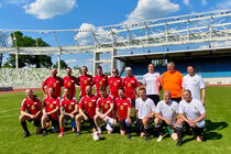 Gruppenbild der beiden Fußballmannschaften auf dem Rasen im Heinz-Steyer-Stadion
