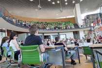 Im Plenarsaal und auf der Besuchertribüne sitzen viele Menschen und verfolgen das Landesfinale.