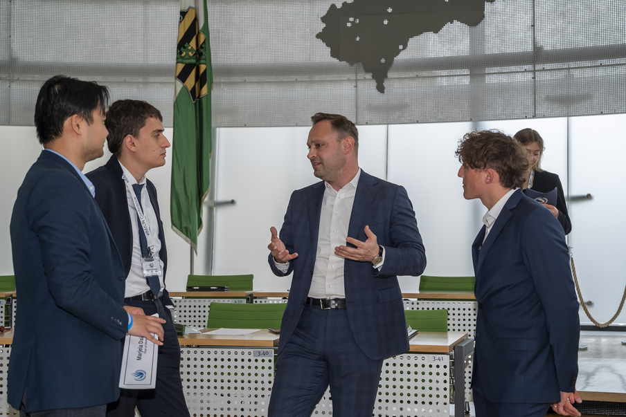 Landtagspräsident Alexander Dierks spricht mit Studierenden im Plenarsaal.