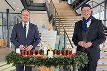 Vertrteter der Diakonie Sachsen steht mit dem Landtagspräsidenten Alexander Dierks am Wichernkranz im Parlament.