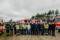 Gruppenbild aller Beteiligten mit Einsatzfahrzeugen in der Gohrischheide
