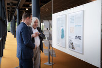 Herr Bauersfeld und der Landtagspräsident stehen vor eine Ausstellungstafel. Beide blicken darauf und der Beauftragte der UOKG erzählt etwas dazu.