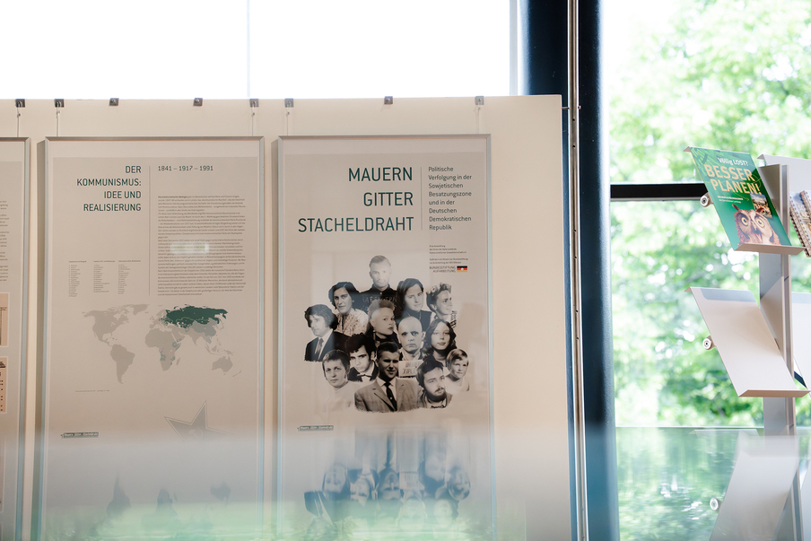 Die erste Tafel der Ausstellung. Darauf zu sehen sind die Gesichter der Menschen, deren Schicksal auf den folgenden Tafeln näher beleuchtet wird.