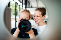 Die Mädchen probieren sich an einer Kamera und fotografieren durch ein Guckloch einer Plenarsaaltür.