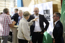 Christian Piwarz und Sören Voigt im Gespräch mit einem Besucher am Informationsstand der CDU