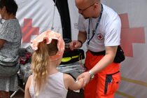 Ein Sanitäter des Deutschen Roten Kreuzes spricht mit einem Mädchen.