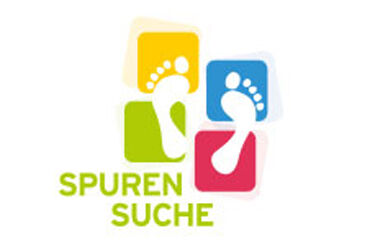 Das Logo der Jugendgeschichtstage wird aus vier verschiedenfarbigen Quadraten gebildet, auf denen zwei weiße Fußabdrücke zu sehen sind. In der linken unteren Ecke befindet sich der grüne Schriftzug: Spurensuche
